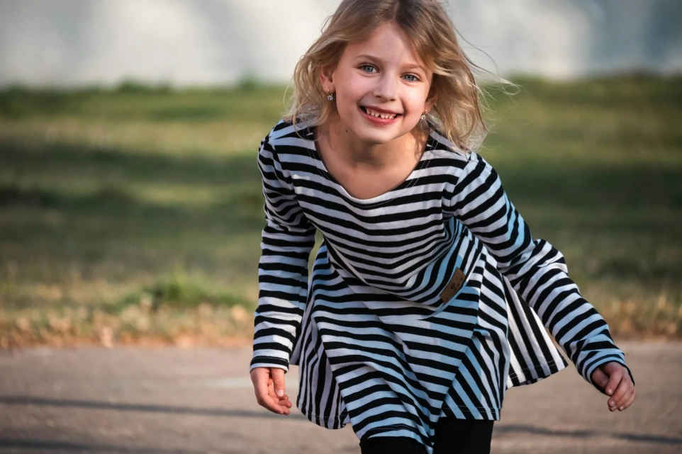 a little girl riding a skateboard down a street